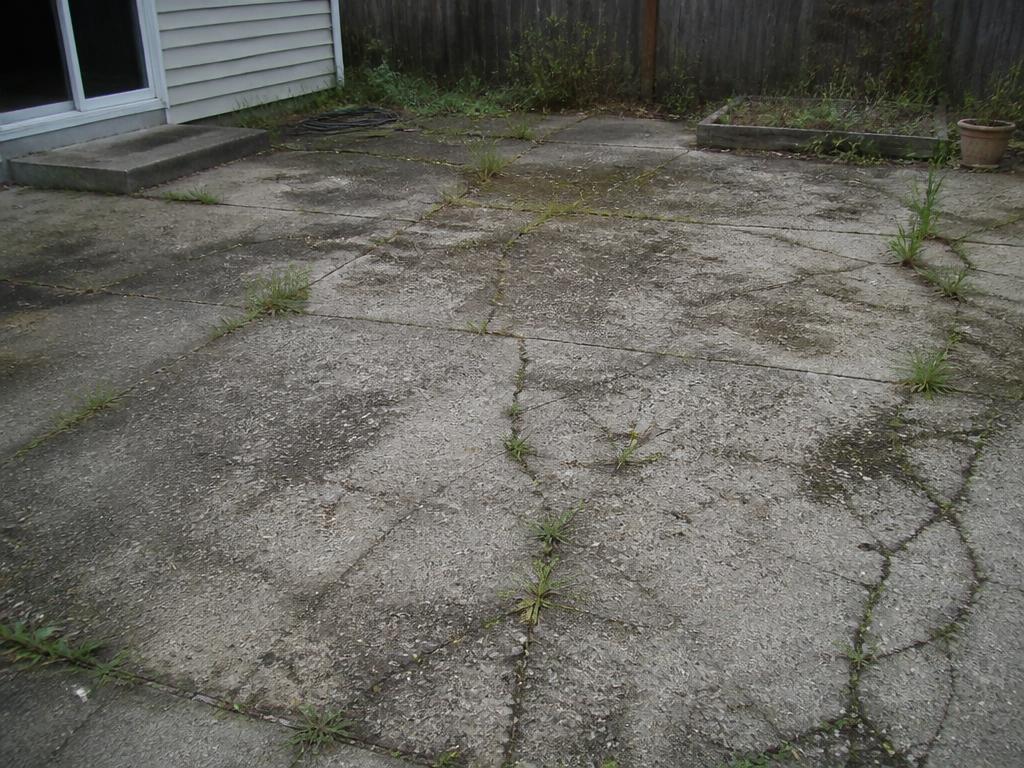 Cracked weathered concrete patio before paver installation